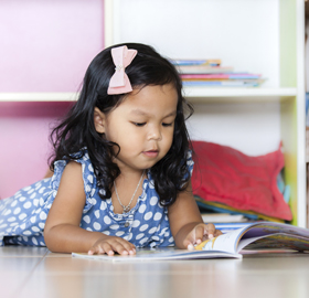 little girl with a book on the floor