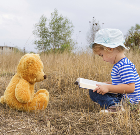 a child with a teddy bear outside
