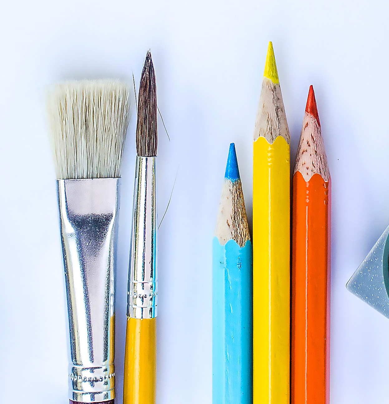 paint brushes and pencil crayons