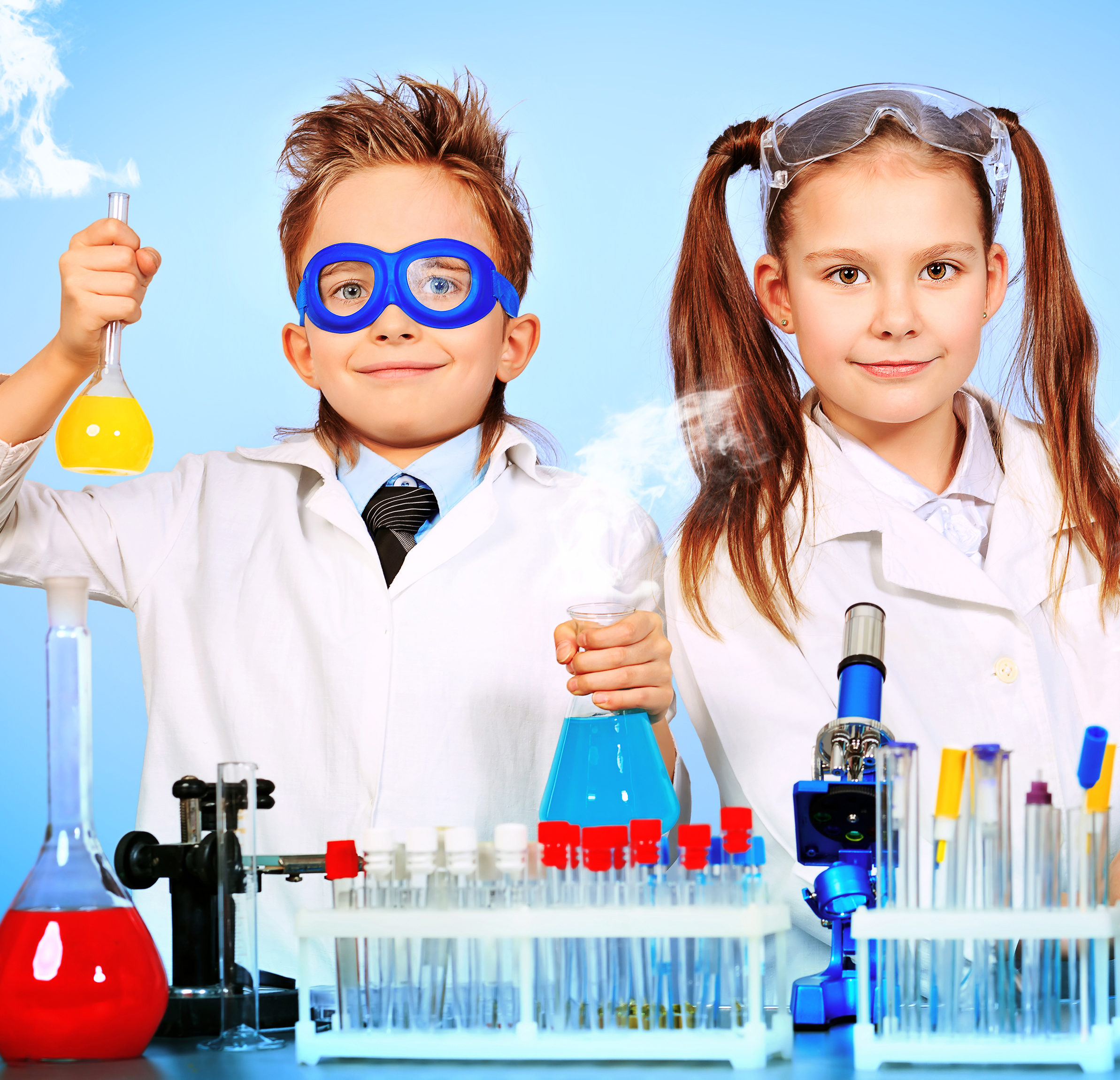 two children in lab coats with vials and beakers