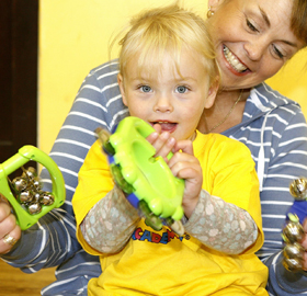 A woman with a little girl on her lap with musical instruments