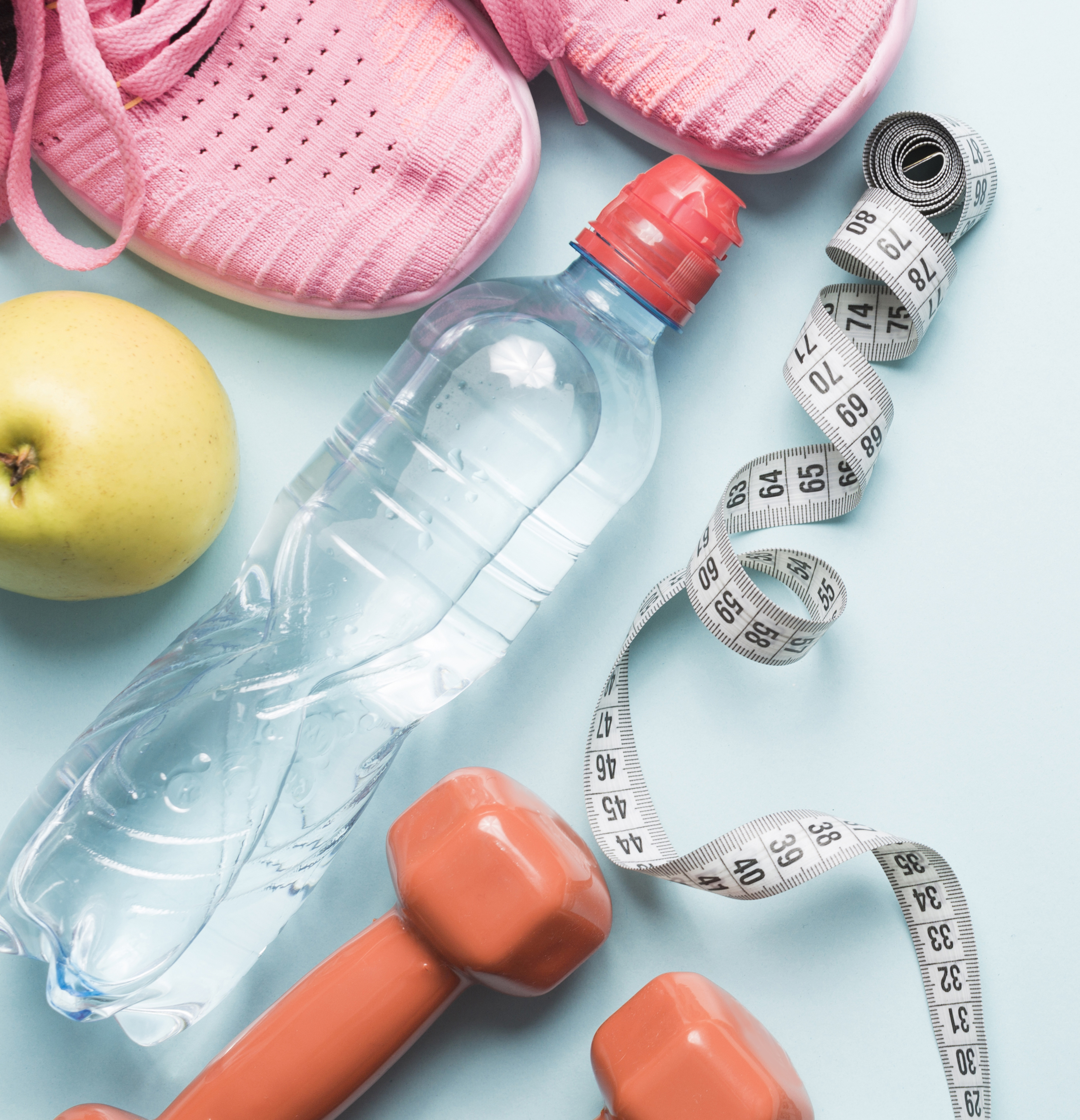 water bottle with running shoes, weights, and an apple