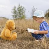 child with book and bear