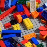 Colourful Lego scattered on a matte grey Lego board.