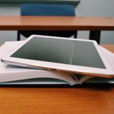 tablet resting on top of open book