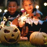 Kids playing with jackolanterns and sparklers.