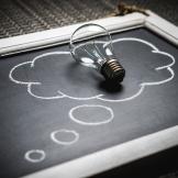 light bulb lying on chalk board thought bubble