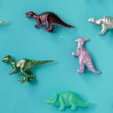 A collection of toy dinosaurs laying on a blue table