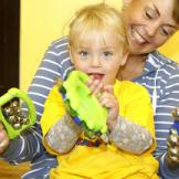 A woman with a little girl on her lap with musical instruments