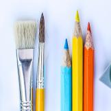 An image of paint brushes and pencils