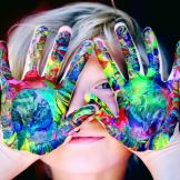 child with multi-coloured paint on their hands
