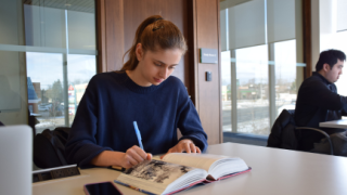 young woman studying at the library