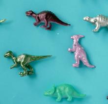A collection of toy dinosaurs laying on a blue table