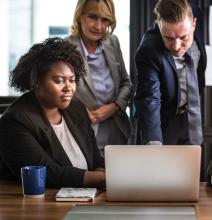 Three people looking at a laptop